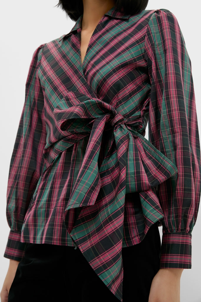 The Tartan Tie Front Bow Bea Blouse showcases a classic wrap design with an effortless, high-end peplum waist and fun oversized bow detail.