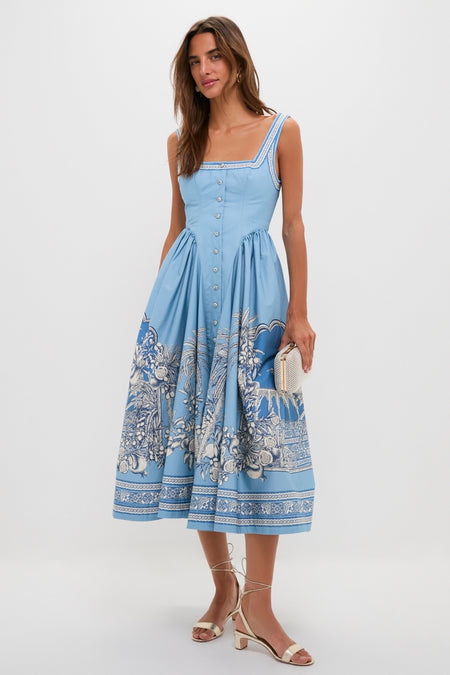 Blue Villa Romantica Midi Dress modeled with classic elegance, featuring a button-front, intricate hem motif, and effortless square neckline, paired with fun metallic sandals.