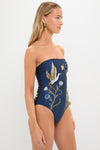 Model showcasing the Laguna Durazno Embroidered One Piece, a classic, high-end strapless swimsuit with intricate heron and floral embroidery, embodying effortless poolside elegance.