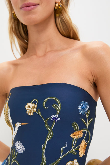 Laguna Durazno Embroidered One Piece: classic, strapless navy bodice adorned with fun, colorful floral embroidery and a crane motif, exuding effortless elegance and high-end style.