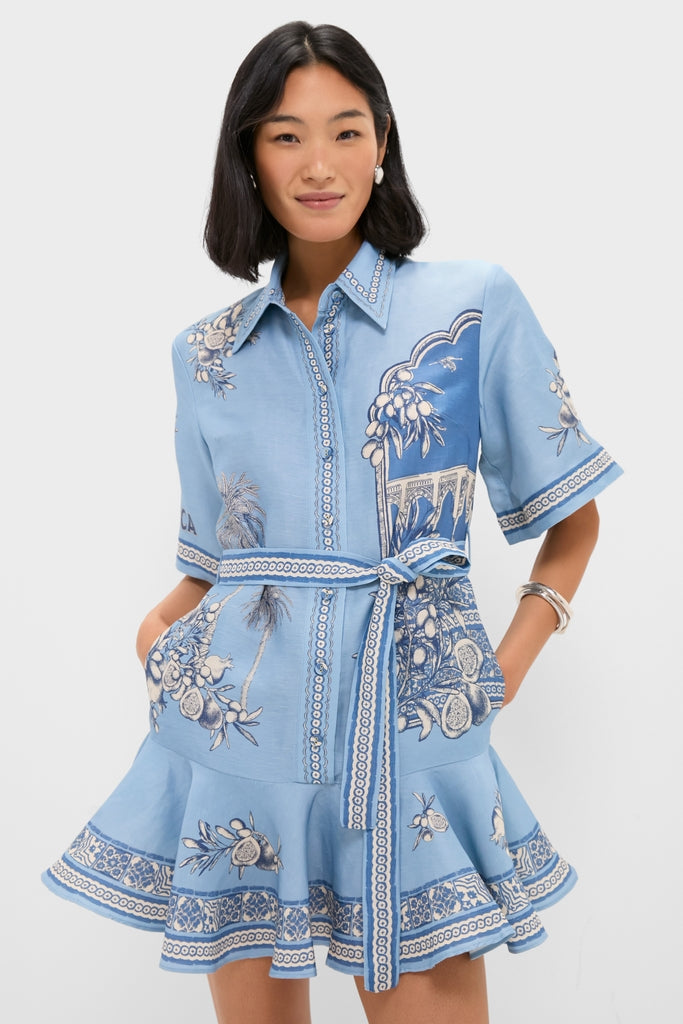 Young woman models the Blue Villa Romantica Mini Dress, a classic and effortless button-front shirt dress featuring a botanical and architectural print, perfect for a high-end, fun look.