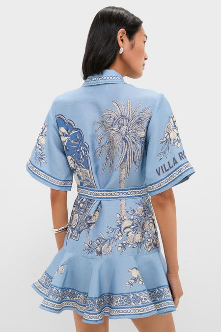Blue Villa Romantica Mini Dress: A classic, effortless sky-blue wrap dress with botanical motifs, elbow-length sleeves, and flared hem, exuding high-end fun and style.