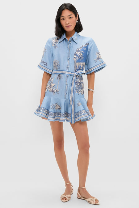 Model wears the Blue Villa Romantica Mini Dress, featuring a classic, effortless design with floral motifs, a flared hem, and a self-fabric belt, paired with strappy sandals.