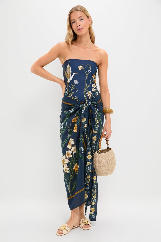 Model in Laguna Lavanda Midi Sarong with botanical motifs, paired with a woven straw handbag and accessories, showcasing a classic, effortless, and fun high-end look.