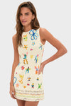 Model wears the Multi Sidi Beaded Mini Dress, showcasing a classic, sleeveless shift with playful hand-painted motifs, exuding effortless fun and sophistication.