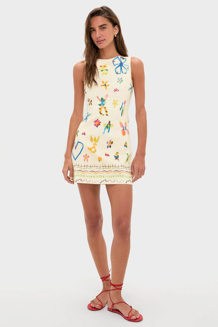 Model in Multi Sidi Beaded Mini Dress with playful artistry; sleeveless, fitted silhouette, high neckline. Styled with red sandals, embodying effortless, high-end sophistication.