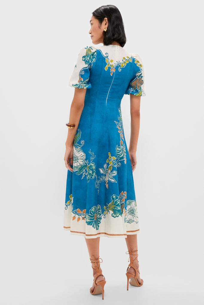 Blue Luda Midi Dress in rich teal-blue with cream panels and botanical print. Features fitted bodice, puff sleeves, A-line skirt. Effortless high-end style for warm weather fun.