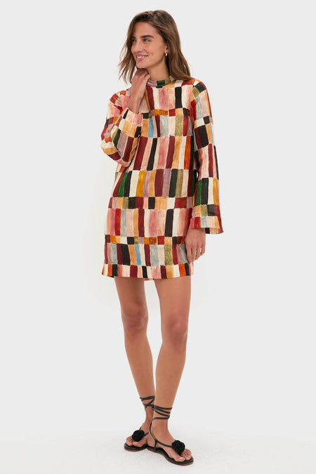 Young woman models the Multi Marjorelle Mini Dress, a classic and effortless shift dress with a painterly stripe pattern, beaded round neckline, styled with fun black floral sandals.