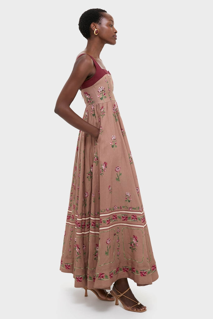 Model wearing the Quebrada Jaspe Maxi Dress, a classic, high-end piece with an A-line silhouette and embroidery, effortlessly styled with chunky earrings and sandals.