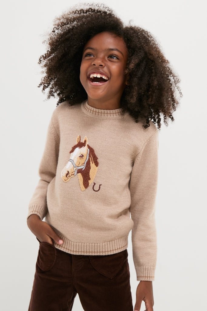 Young girl in a Jacquard Head Horse Jumper, featuring a classic horse motif, effortlessly styled with dark brown corduroy pants, embodying high-end fun and timeless elegance.