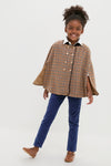 Young girl in a classic, high-end Checked Double Breasted Cape in Brown, showcasing effortless style with decorative buttons and velvet collar, paired with fitted pants and chic shoes.