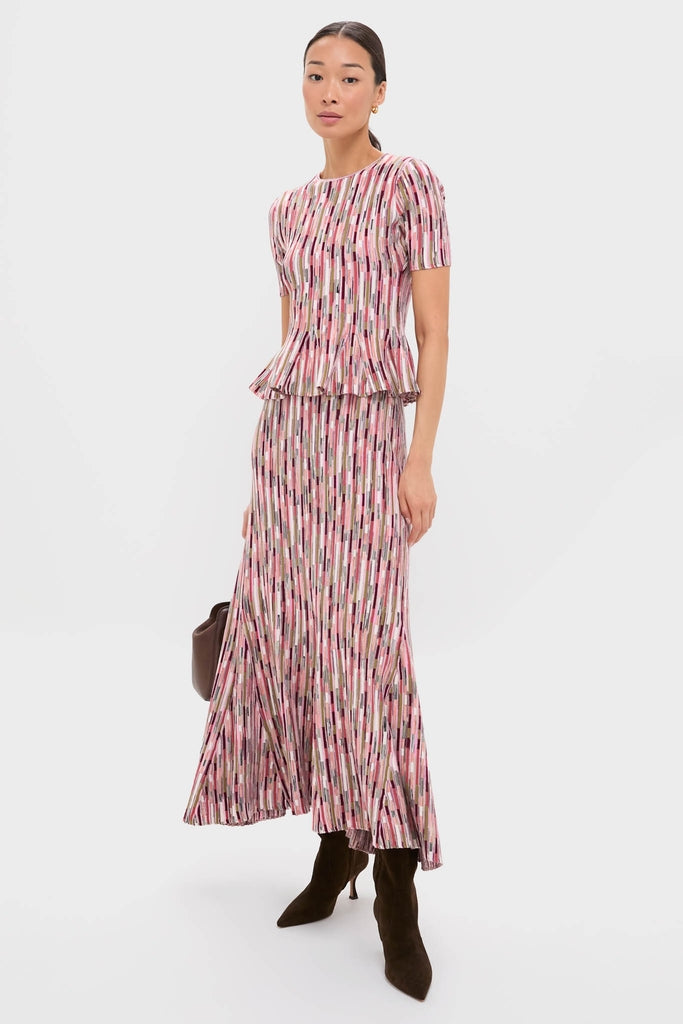 Woman models the Rosewood Marceline Skirt, a classic, effortless, high-end midi with vibrant stripes and peplum top, paired with suede boots and a handbag.