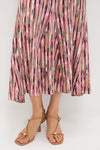 Rosewood Marceline Skirt: Classic, effortless midi with vibrant stripes, high-rise, elastic waistband, and a flared hem. Paired with nude-tan heeled sandals for a fun, high-end look.