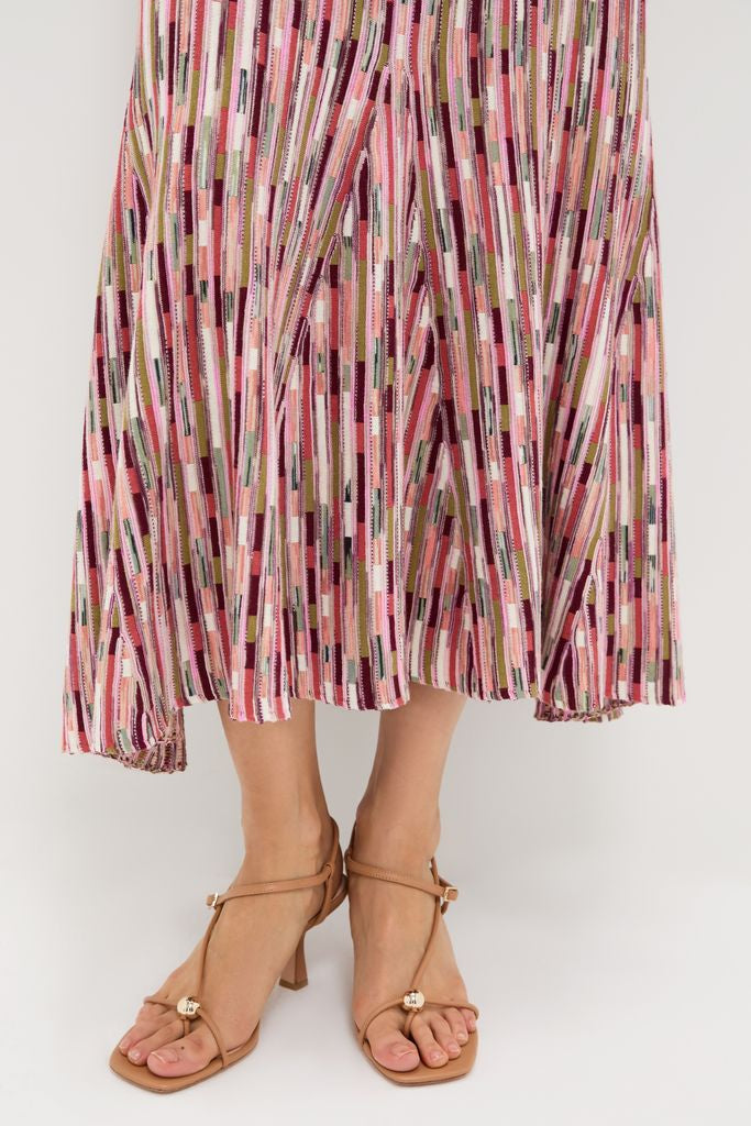 Rosewood Marceline Skirt: Classic, effortless midi with vibrant stripes, high-rise, elastic waistband, and a flared hem. Paired with nude-tan heeled sandals for a fun, high-end look.