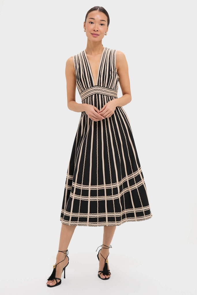 Noir Palermo Dress: Classic, effortless A-line with a deep V-neck, grid pattern, and tassel-detailed heels, epitomizing high-end, fun fashion.