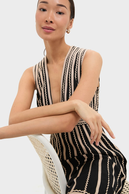 Woman models the classic Noir Palermo Dress, featuring a plunging V-neck, vertical stripes, and elegant line details, embodying effortless, high-end style.