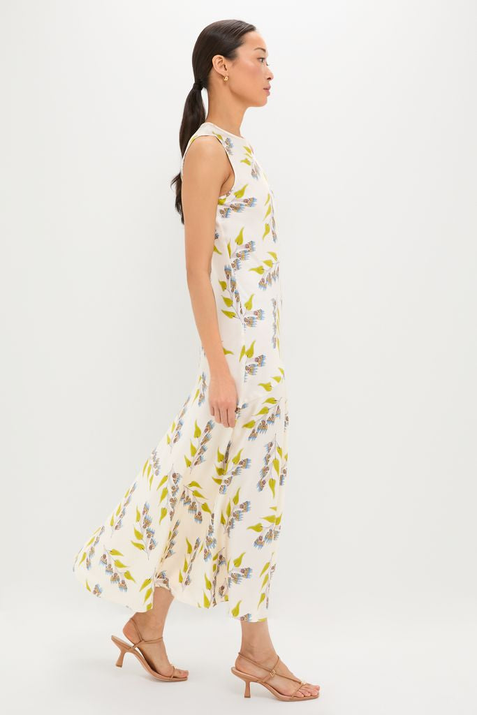 Model in profile wearing the classic Infinite Flower Gaea Dress, featuring an effortless botanical motif, paired with fun, high-end tan sandals.
