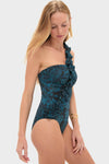Model in an Eclipse Flora Capri Maillot, a classic, one-shoulder swimsuit with teal floral print and ruffled trim, embodying Tuckernuck’s effortless and high-end style.
