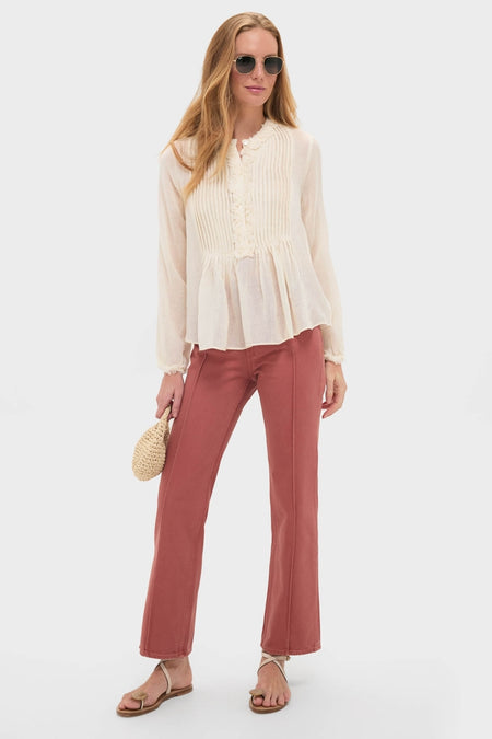 Model in classic Garden Rose Agatha Jean, featuring an effortless ivory blouse with pintuck detail, rust straight-leg pants, and fun strappy sandals, embodying high-end style.