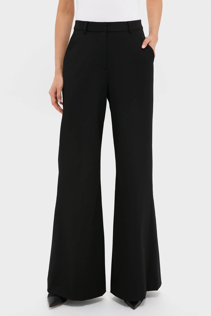 Woman wearing classic Black Pillar Wide Leg Pant with high-rise and wide-leg design, paired effortlessly with a white top and pointed-toe shoes for a high-end, fun look.