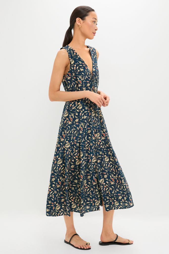 Woman wearing the classic Midnight Garden Carina Dress, an effortless deep-V midi with a floral pattern, paired with black sandals for a fun, high-end look.