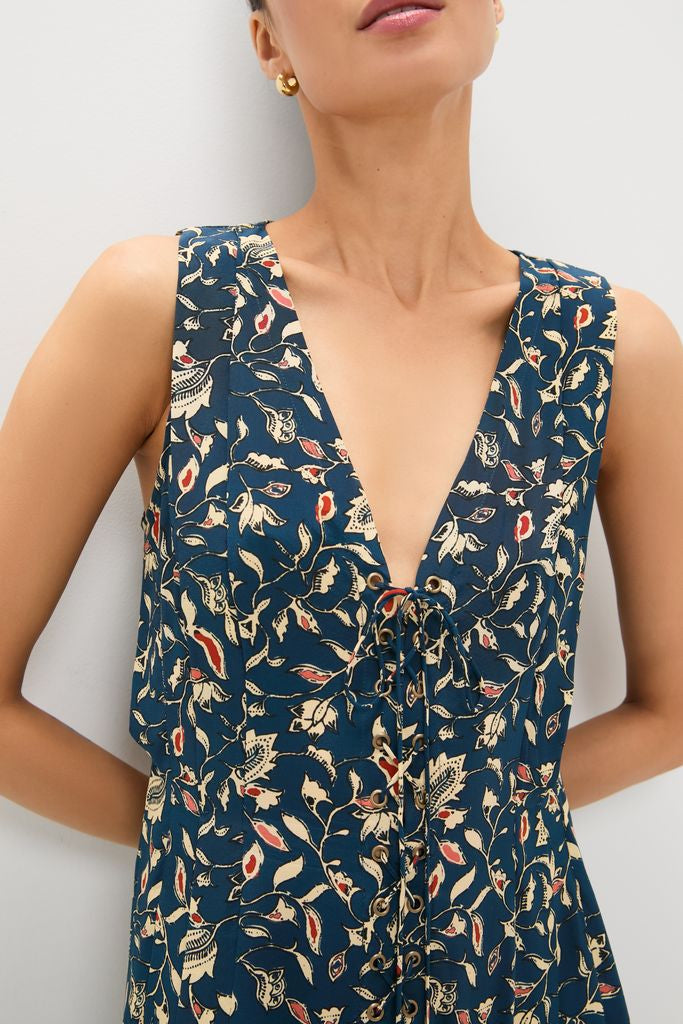 Woman wearing the Midnight Garden Carina Dress, a classic sleeveless, deep-V dress with a floral print and lace-up detail, styled with a gold hoop earring for an effortless, high-end look.