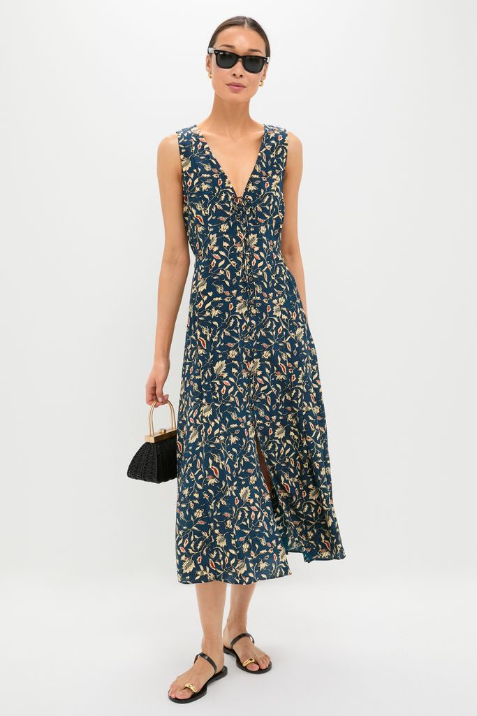 Model in the classic Midnight Garden Carina Dress with botanical print, paired with an effortless black handbag, flat sandals, sunglasses, and gold earrings for a high-end, fun look.