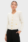 Ivory Una Knit Cardigan, a classic eyelash knit with gold crest buttons and patch pockets, paired effortlessly with high-waisted trousers, embodying high-end, fun style.