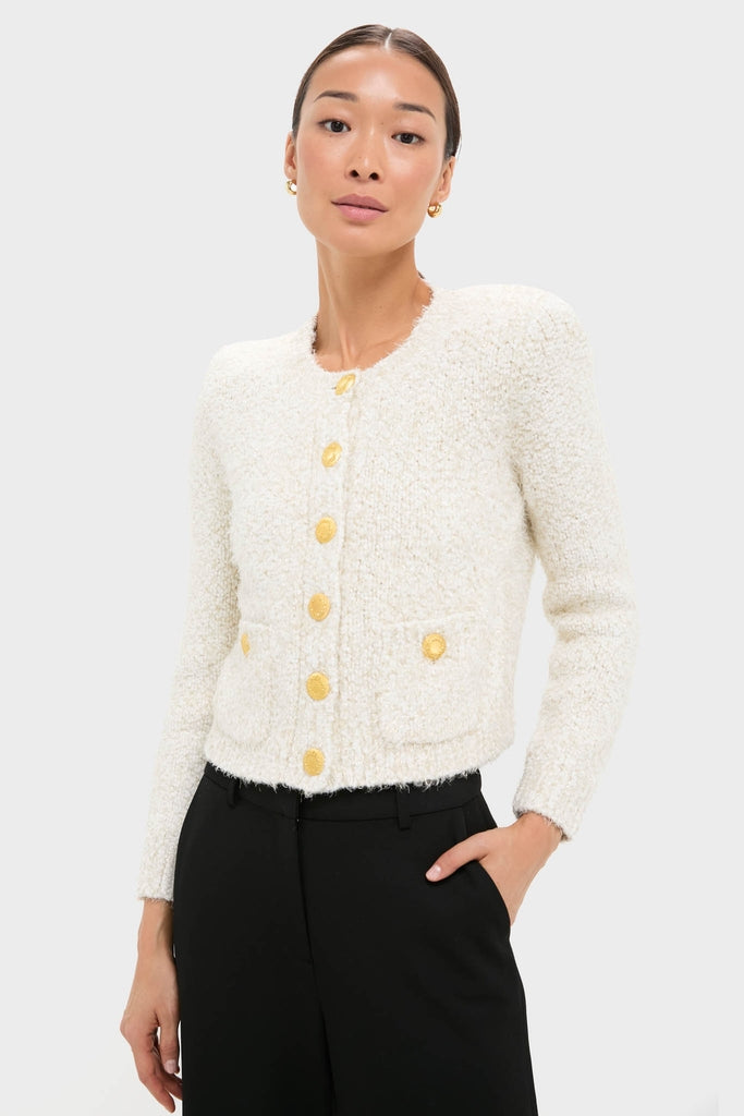 Ivory Una Knit Cardigan, a classic eyelash knit with gold crest buttons and patch pockets, paired effortlessly with high-waisted trousers, embodying high-end, fun style.