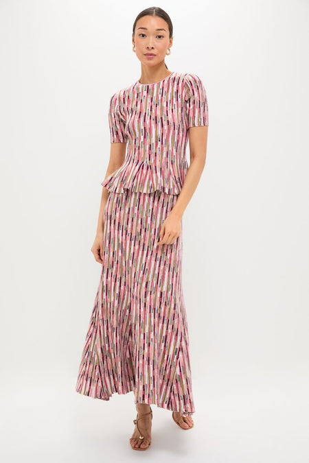 Woman in classic Rosewood Samira Pullover and matching skirt, featuring an effortless ribbed, knit design with vertical stripes, styled with strappy sandals and hoop earrings for a fun, high-end look.