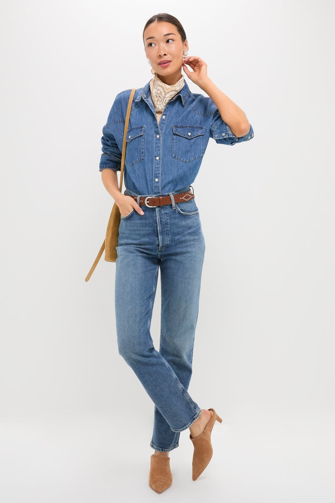 Woman wearing a denim ensemble and hoop earrings, showcasing Camel Suede Whipstitch Kathryn Mules. The classic, high-end mules add an effortless, fun touch to her casual look.