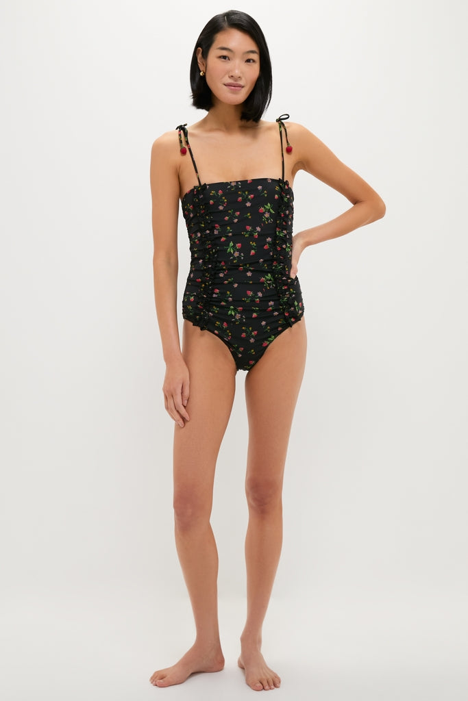 Model in a classic, fun Multi Katarina Print Tie Strap One Piece swimsuit, featuring ruched sides and playful pom-pom straps, embodying effortless, high-end style.