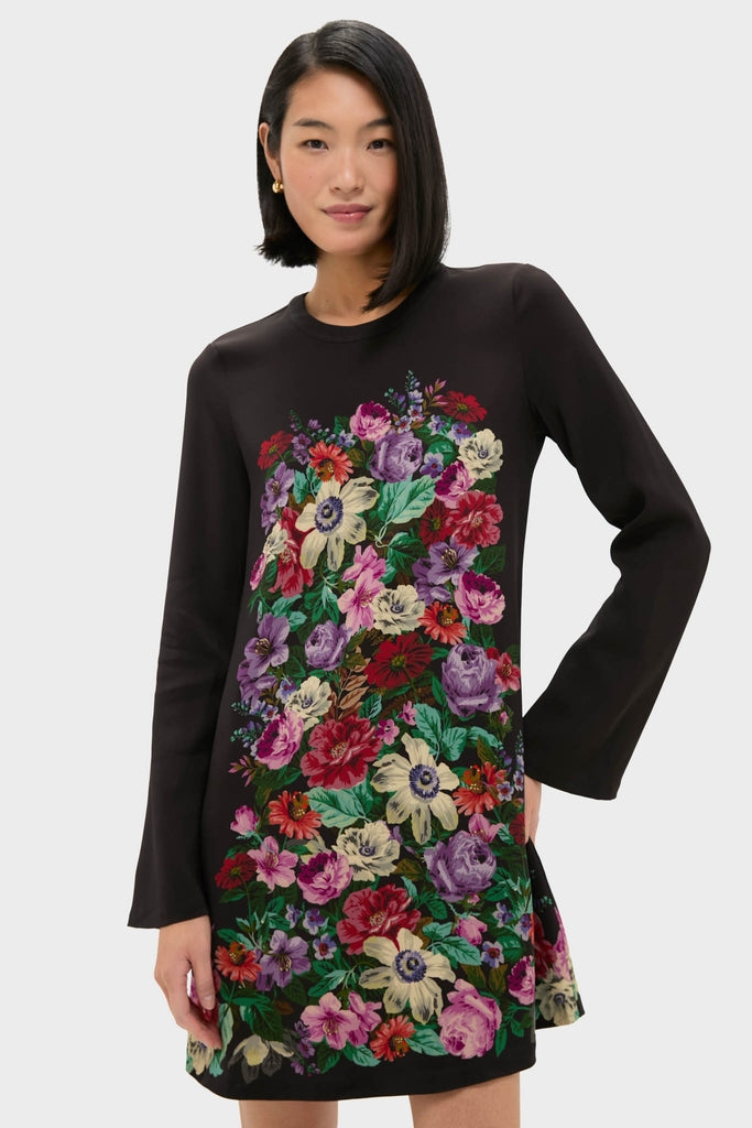 Model wearing the Multi Viktoria Print Long Sleeve Mini Dress, a classic, vibrant floral A-line piece, exuding an effortless and fun high-end style against a light-gray background.