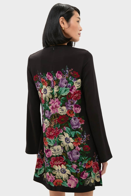 A woman models the Multi Viktoria Print Long Sleeve Mini Dress, featuring an effortless, high-end floral design on the back, embodying Tuckernuck's classic and fun style.