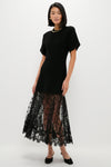 Black Diane Knit Lace Combo Knit Dress: A classic, effortless high-end design featuring a short-sleeved black top and sheer lace skirt with floral embroidery, styled with minimal gold jewelry.
