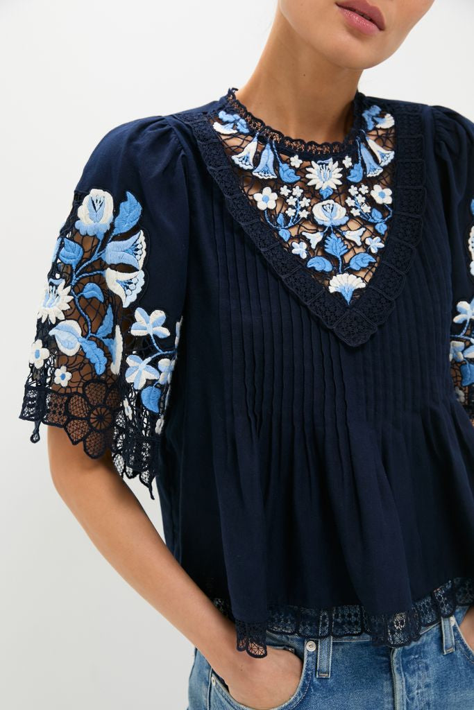 Exclusive Navy Edwina Embroidery Short Sleeve Top with classic floral embroidery, lace inserts, and pintucks, offering an effortless, high-end style paired with fun denim.