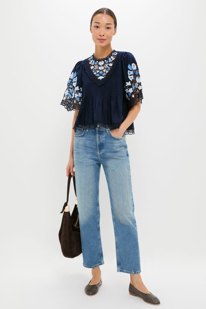 Exclusive Navy Edwina Embroidery Short Sleeve Top, featuring classic floral embroidery, lace trim, and pintuck details, exudes an effortless, high-end style paired with light denim jeans.