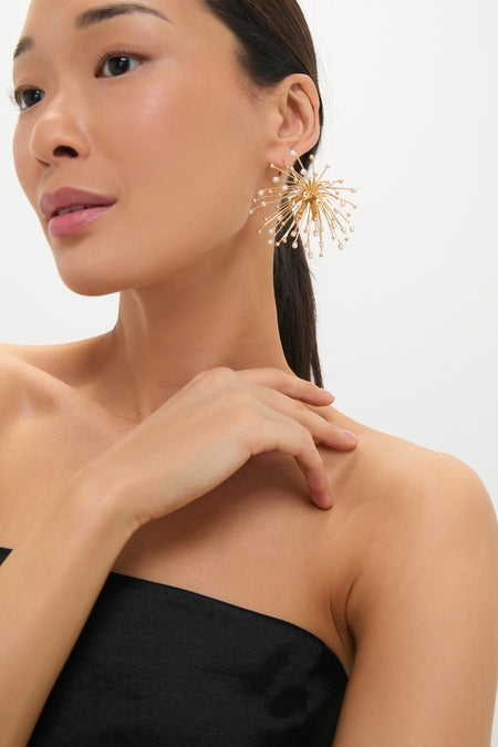 Close-up of a woman wearing Pearl Damita Earrings, showcasing a classic, high-end gold burst design with pearl-tipped wires, embodying effortless style and fun sophistication.