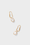 Brushed Brass Vera Earrings: Organic-shaped gold-tone loops with baroque-style pearls, offering a classic yet modern, effortless, and fun high-end design.