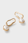 Brushed Brass Vera Earrings feature classic, effortless gold-tone loops with baroque pearls, offering a high-end, fun accessory for those seeking stylish elegance.