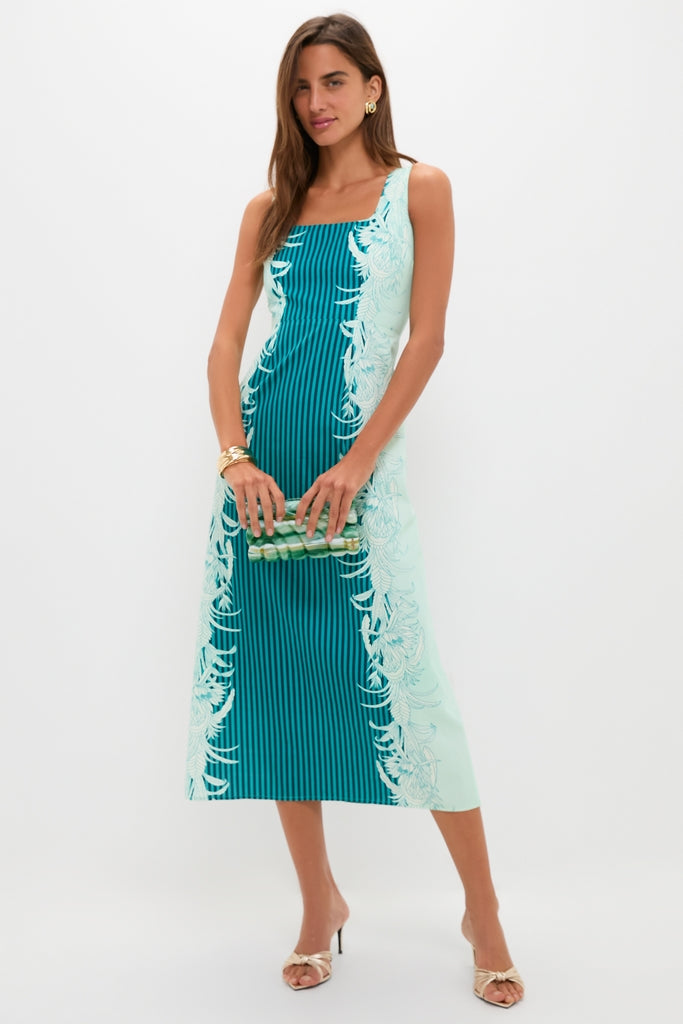 Model holding the Sage Aura Clutch, a translucent, high-end accessory with green accents, complementing her classic, sleeveless dress, effortlessly styled with gold jewelry for a fun, chic look.