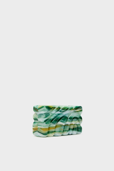 Sage Aura Clutch, a high-end, sculptural accessory in marbled resin, features an effortless, classic design with wavy ripples for a fun, sophisticated look.