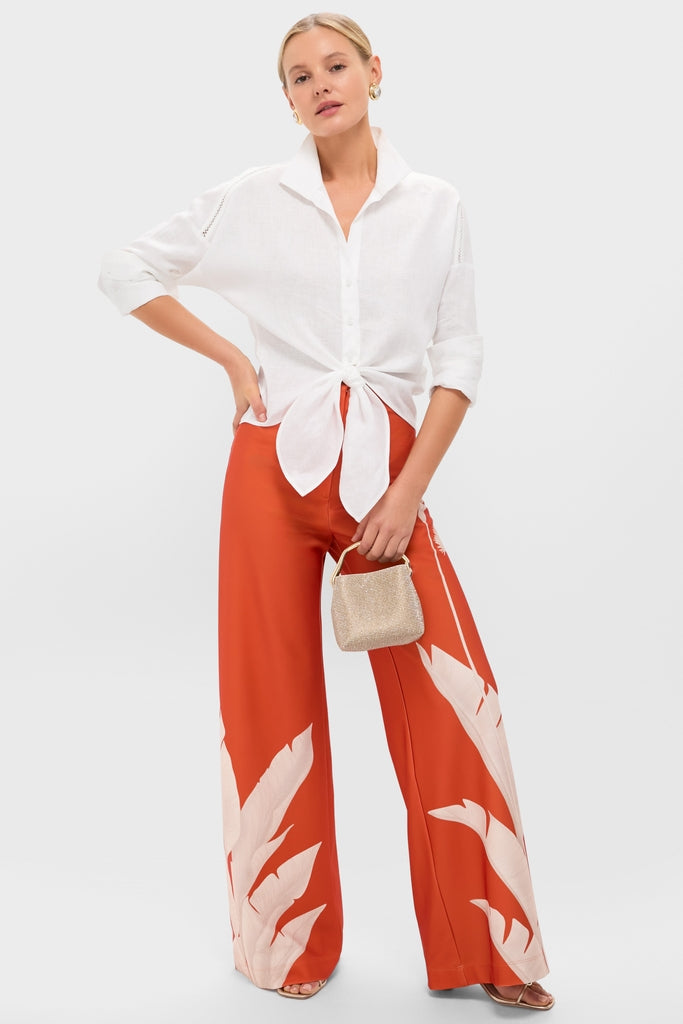 Woman in classic, effortless attire holding the Sand Dollar Solene Mini Top Handle, a high-end, glittery gold handbag perfect for fun, chic occasions.