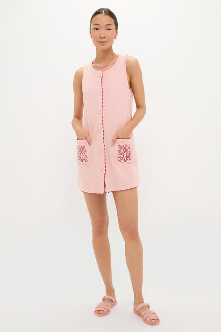Woman wearing a classic Coral Embroidered Mini Bermuda Terrycloth Coverup, featuring scalloped trim, coral embroidery, and front pockets, paired with effortless slide sandals and fun accessories.