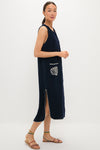 Model in Navy Embroidered Bermuda Terrycloth Caftan, a classic, sleeveless midi dress with scalloped trim, seashell patch pocket, and high side slit, exuding effortless, high-end style.