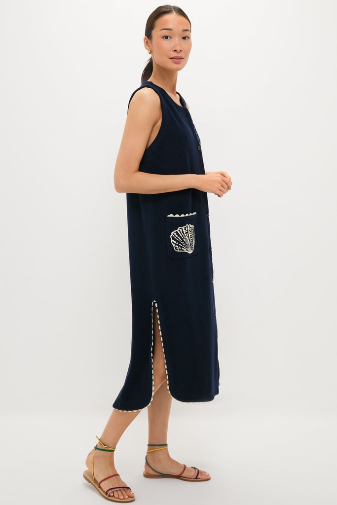 Model in Navy Embroidered Bermuda Terrycloth Caftan, a classic, sleeveless midi dress with scalloped trim, seashell patch pocket, and high side slit, exuding effortless, high-end style.