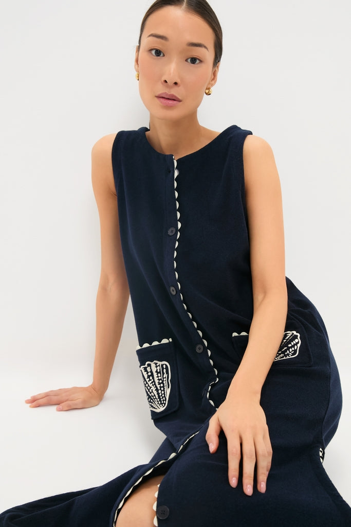 Young woman in a classic Navy Embroidered Bermuda Terrycloth Caftan with scalloped edges and seashell embroidery, capturing an effortless, high-end style for fun, confident wear.