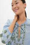 Young woman in a classic Sky Geometric Embroidered Long Sleeve Salty Paloma Caftan, featuring effortless green and white patterns, exudes a fun, high-end vibe.