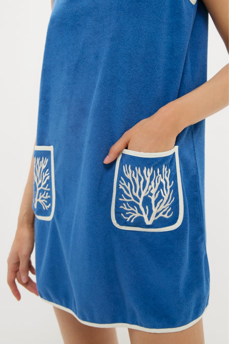 Cobalt Embroidered Terrycloth Dress Coverup: A classic, sleeveless cobalt-blue tunic with white-trimmed pockets featuring coral motifs, embodying effortless, high-end style. Perfect for fun, confident outings.