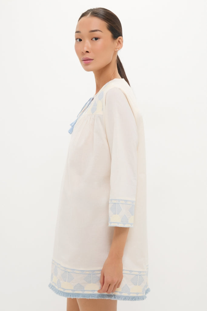 Young woman models the classic Neblina Geometric Embroidered Bondi Coverup, showcasing its effortless, high-end design with fun geometric embroidery and a fringe trim.